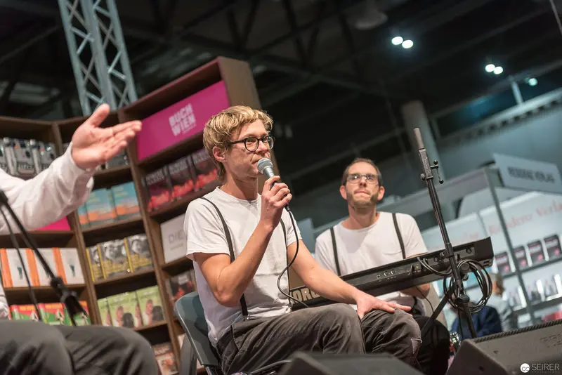 Microphone Performance at Book Fair with Electronic Musical Equipment