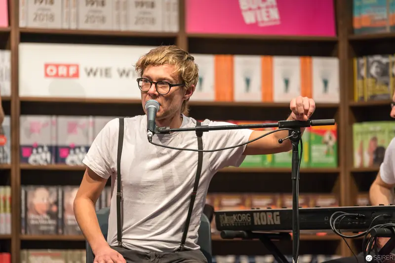 Performer with Microphone and Suspenders at Bookstore Event