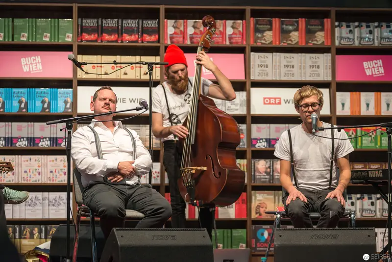 Acoustic Trio Performing at Bookstore Event with Upright Bass and Intimate Stage