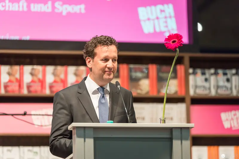 Buch Wien 2017 Opening: Speaker at Podium with Pink Gerbera Flower