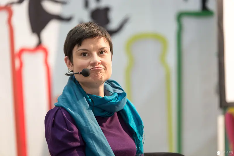 Lena Raubaum Speaking at Conference with Expressive Microphone Gesture