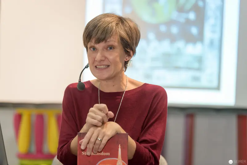 Academic Presentation with Microphone and Book at Scholarly Event