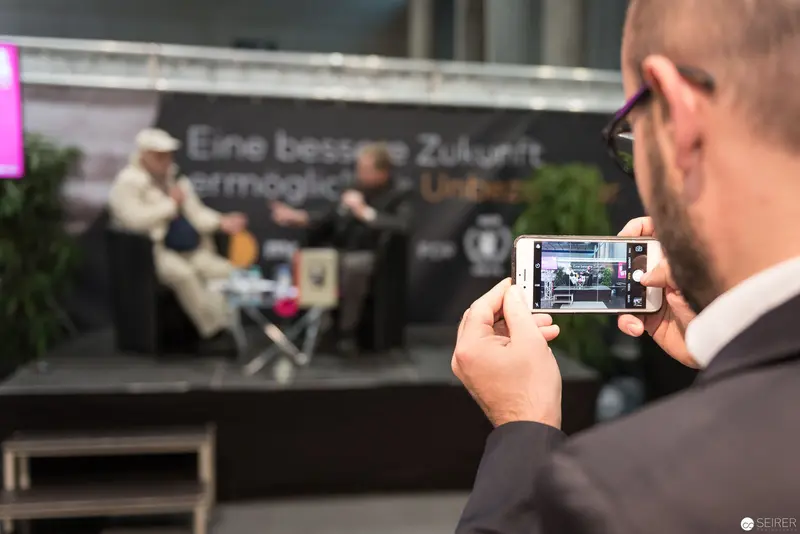 Documenting Contemporary Event: Photographer Captures Panel Discussion on Smartphone