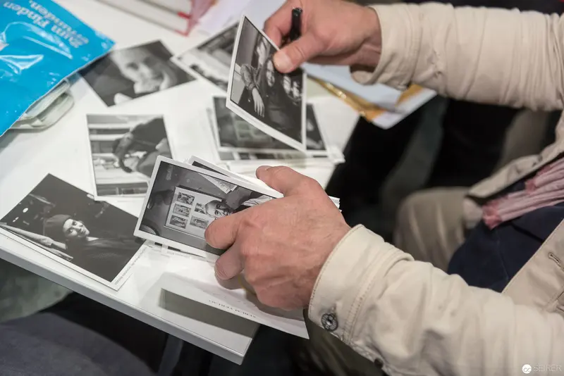 Hands Sorting Black and White Archival Photographs at Book Event
