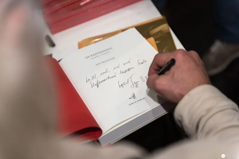 Book Signing at Wien 2017: Close-up of Signing Hand and Open Volume