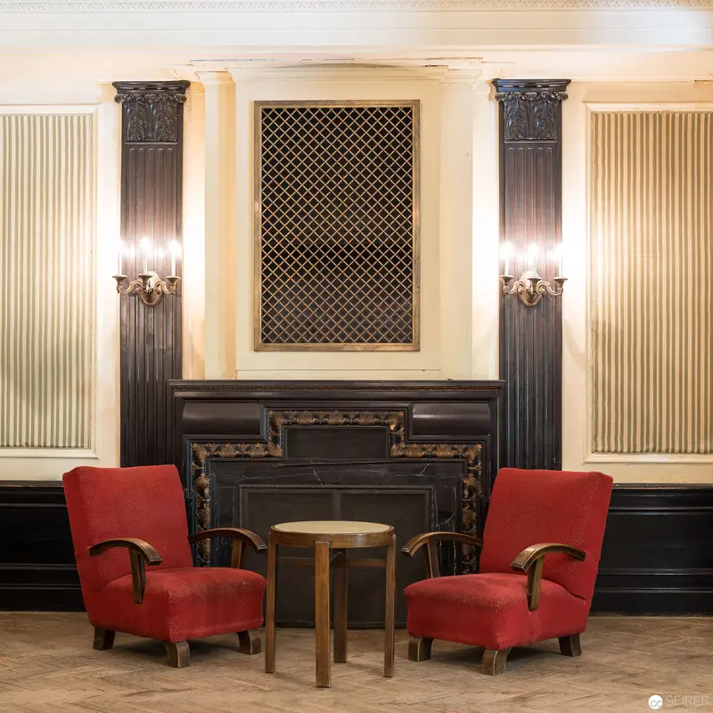 Elegant Art Deco Interior with Red Armchairs and Decorative Fireplace