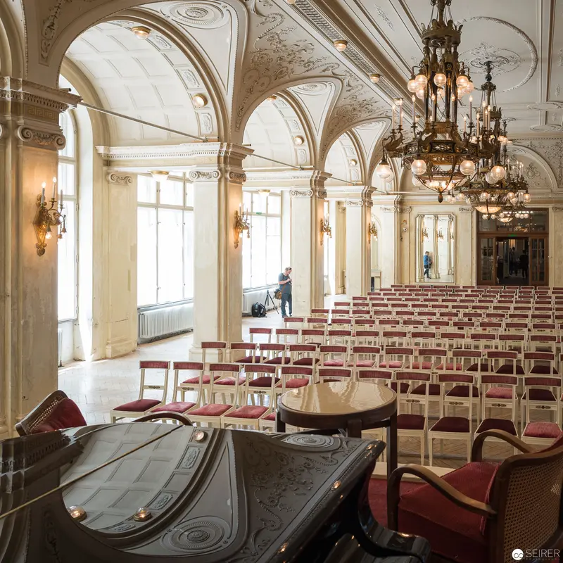 Ornate Concert Hall Interior with Elegant Arched Windows and Vintage Chandelier
