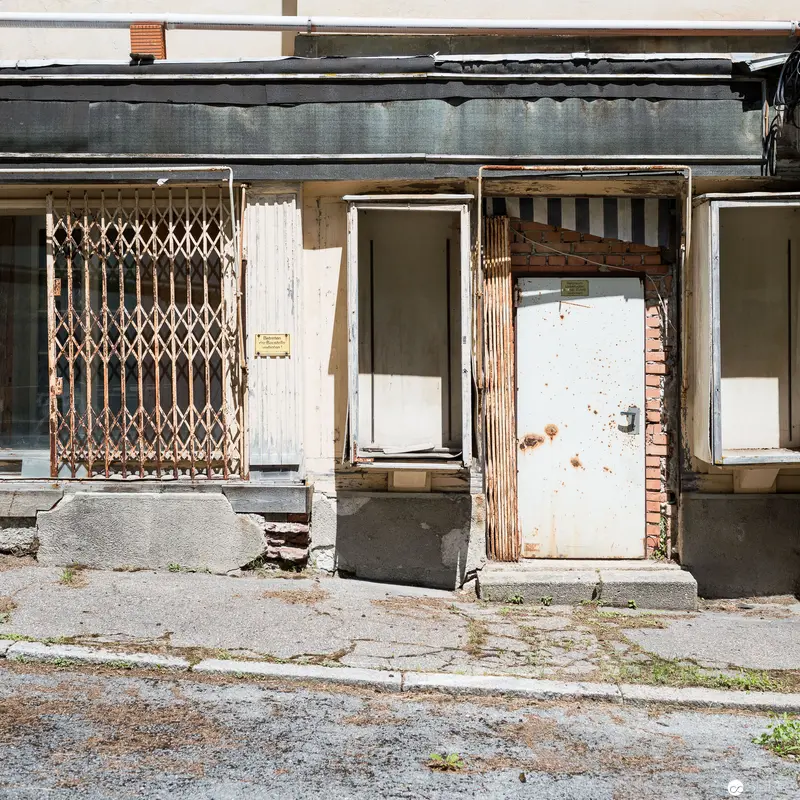Abandoned Urban Storefront with Decaying Façade and Rusted Metalwork