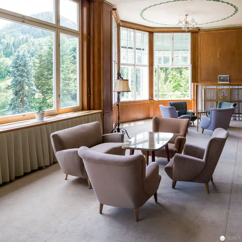 Mid-Century Modern Lounge with Panoramic Forest Views and Minimalist Seating
