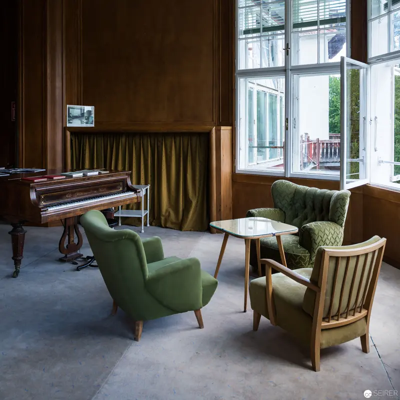Mid-Century Modern Interior with Vintage Piano and Green Armchairs