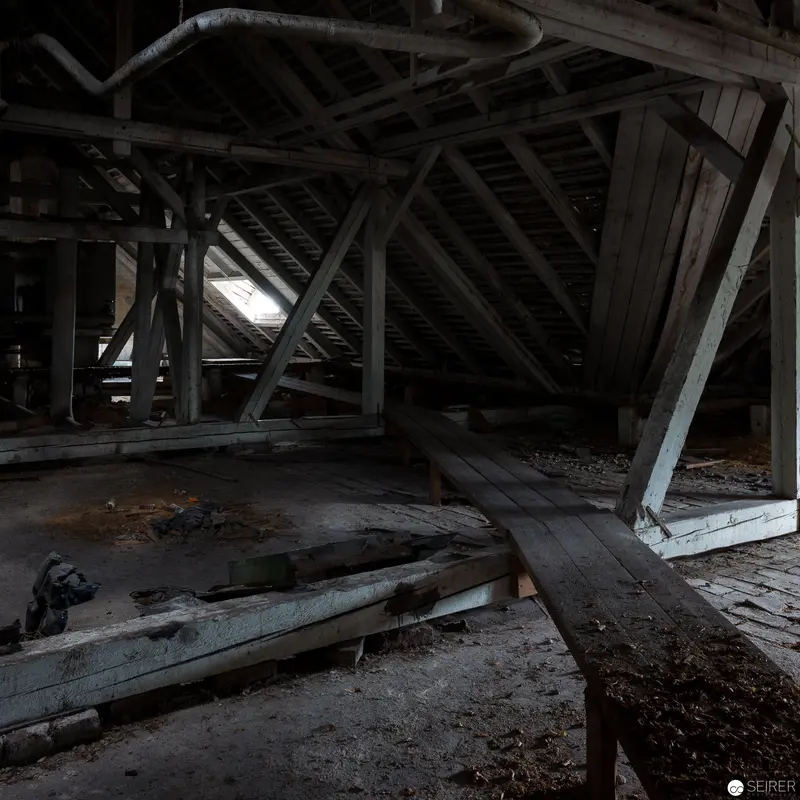 Abandoned Attic Interior with Decaying Wooden Structural Framework and Fragmented Beams