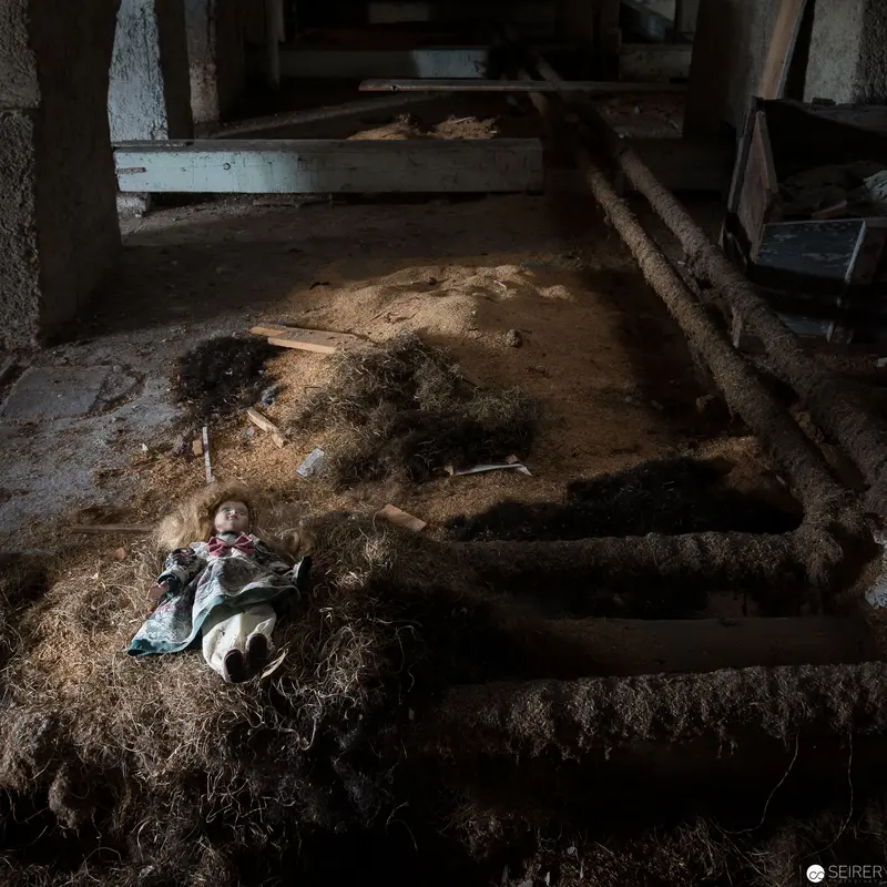 Abandoned Doll in Desolate Interior, Stark Illumination Revealing Decay