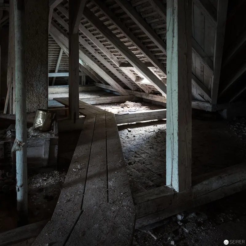 Abandoned Attic Interior with Weathered Wooden Beams and Dust-Laden Atmosphere