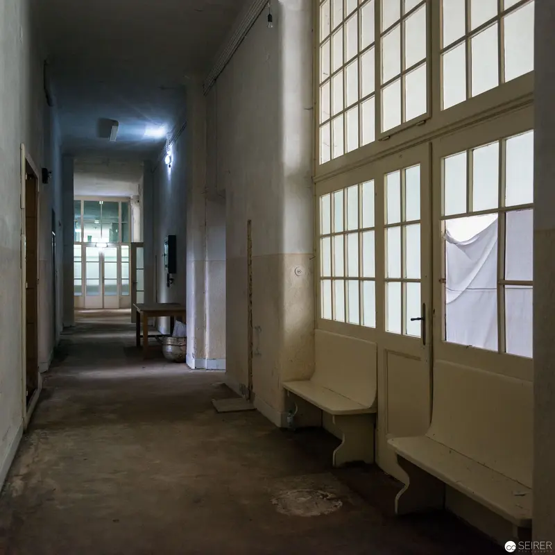 Institutional Corridor with Large Windows and Pale Architectural Surfaces