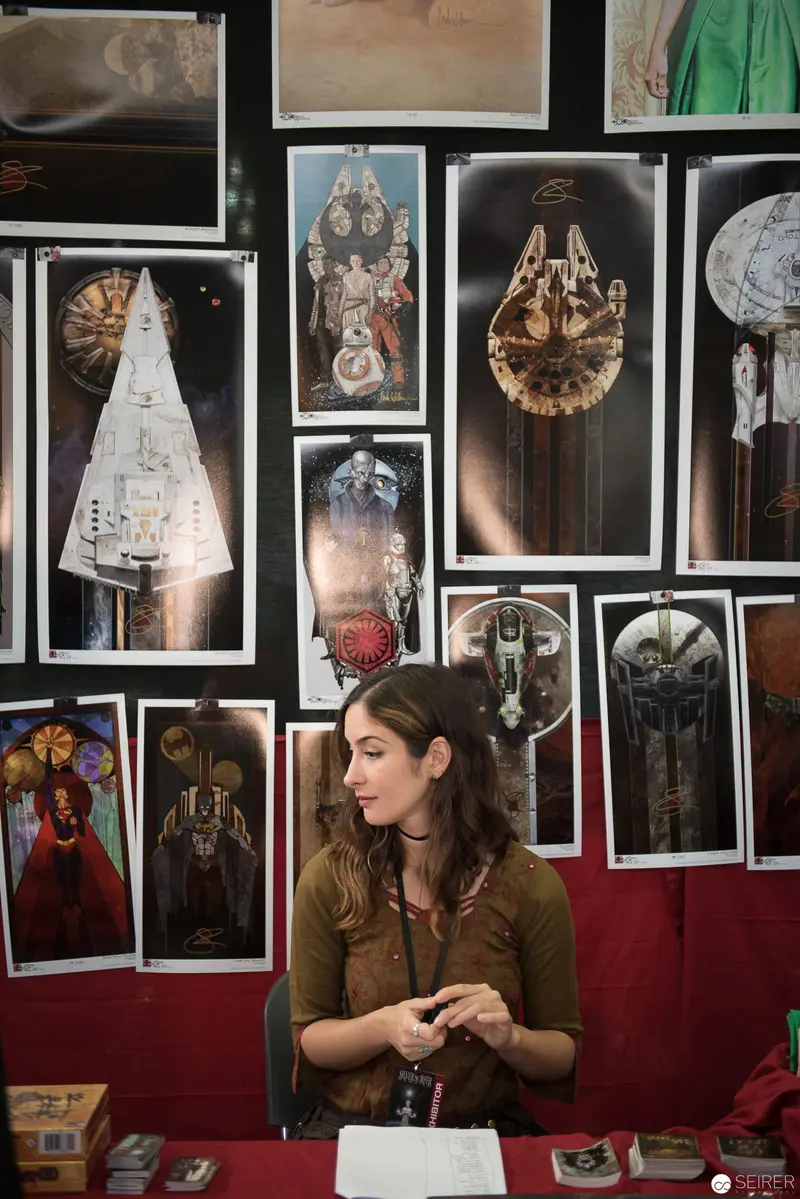 Curator Surrounded by Intricate Mechanical Device Photographs at Exhibition Display