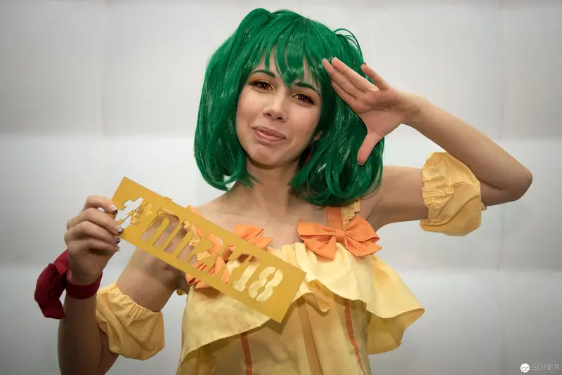 Cosplay Portrait of Woman in Green Wig and Yellow Dress with Gold Banner