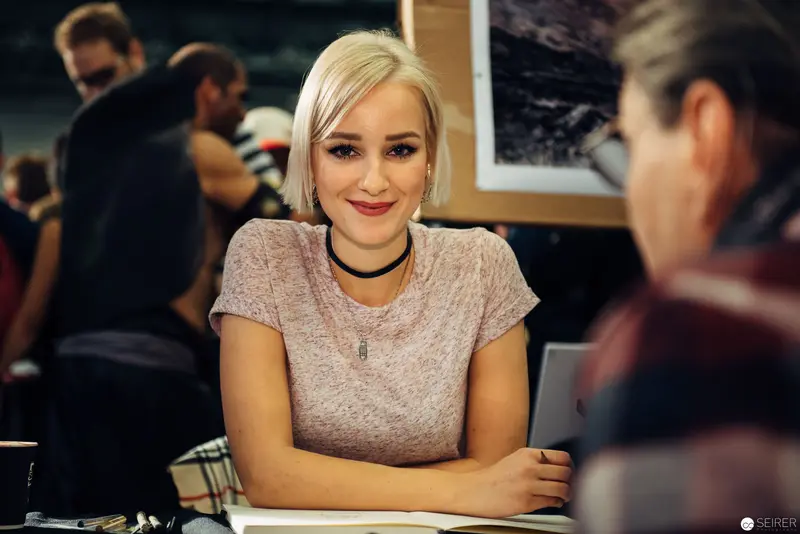Young Professional at Workspace with Warm Lighting and Casual Attire