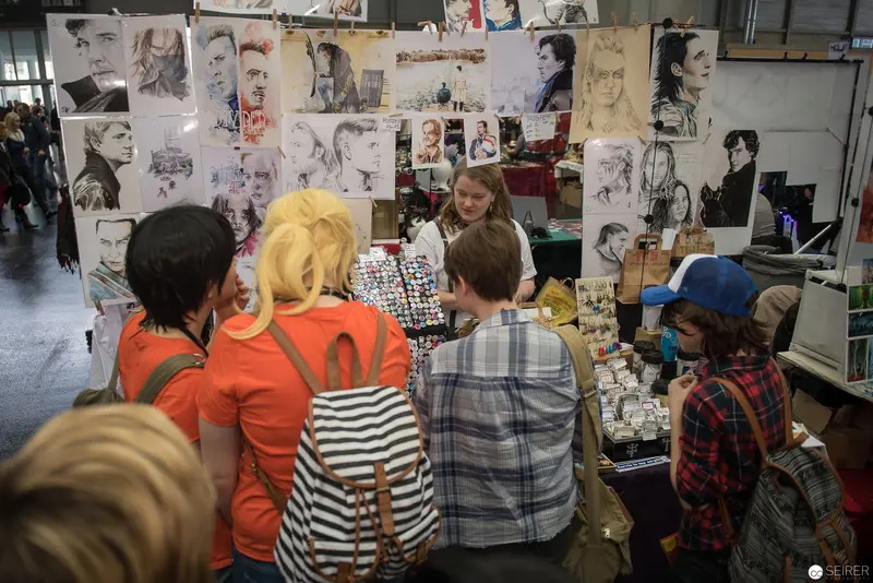 Art Students Examining Portraits at Sketching Exhibition Display Wall
