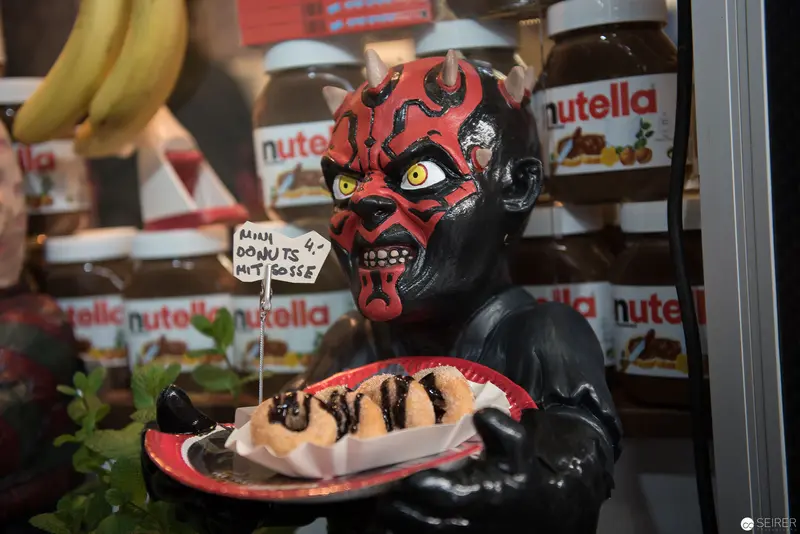 Darth Maul Mascot Presenting Nutella-Drizzled Pastry Among Retail Display
