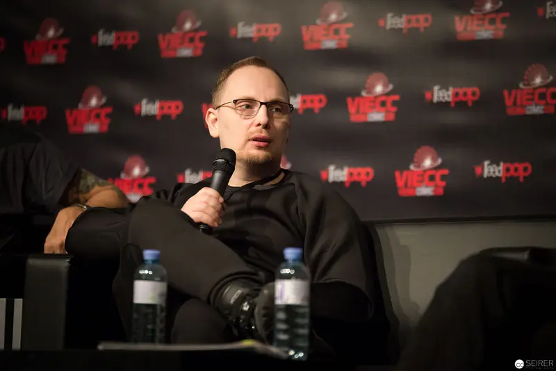Speaker at VUECC Conference Discussing with Microphone and Water Bottles