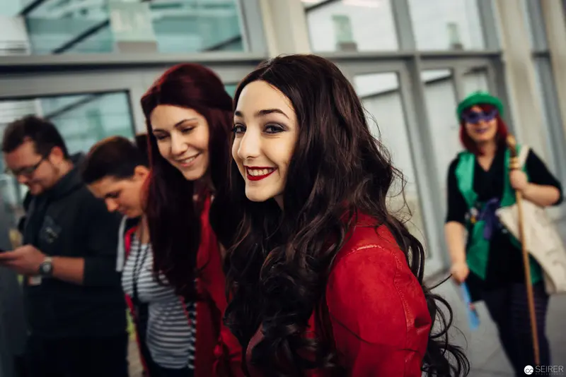 Young Women in Red and Dark Hair Smiling in Urban Interior Setting