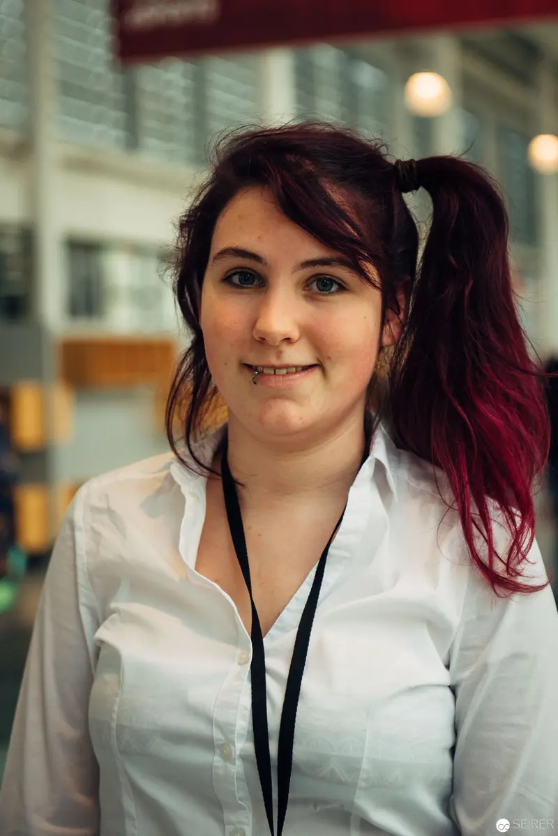 Young Professional in White Shirt with Burgundy Hair in Urban Office Setting