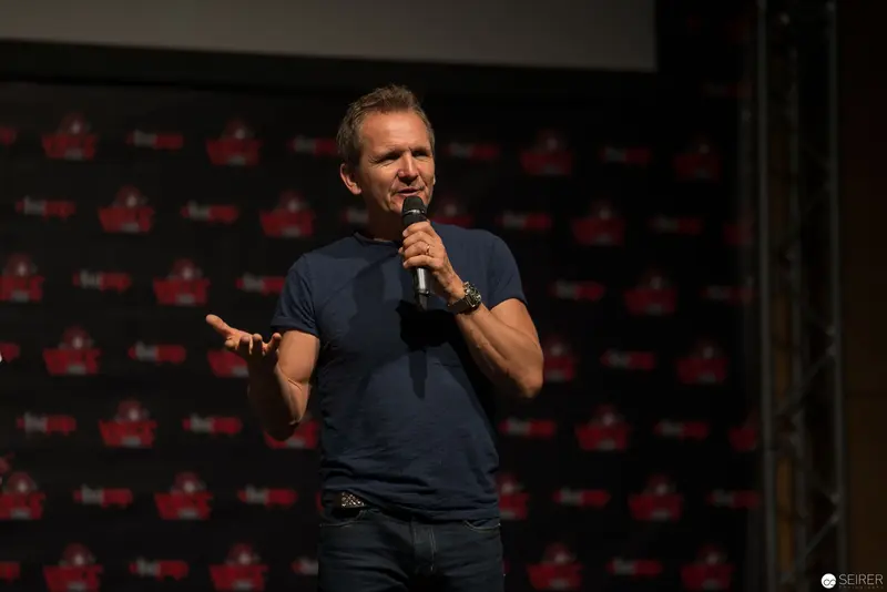 Comedian Performing Standup on Stage with Branded Backdrop