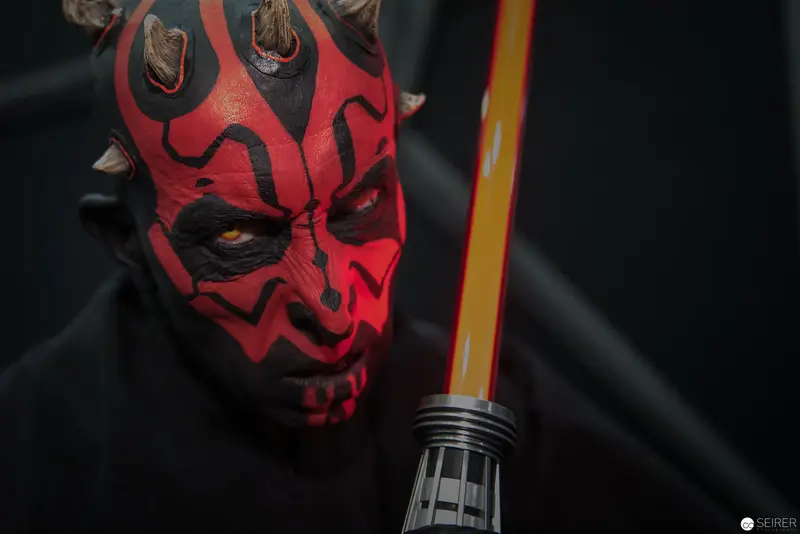 Sith Lord Darth Maul with Illuminated Lightsaber in Dark Dramatic Portrait