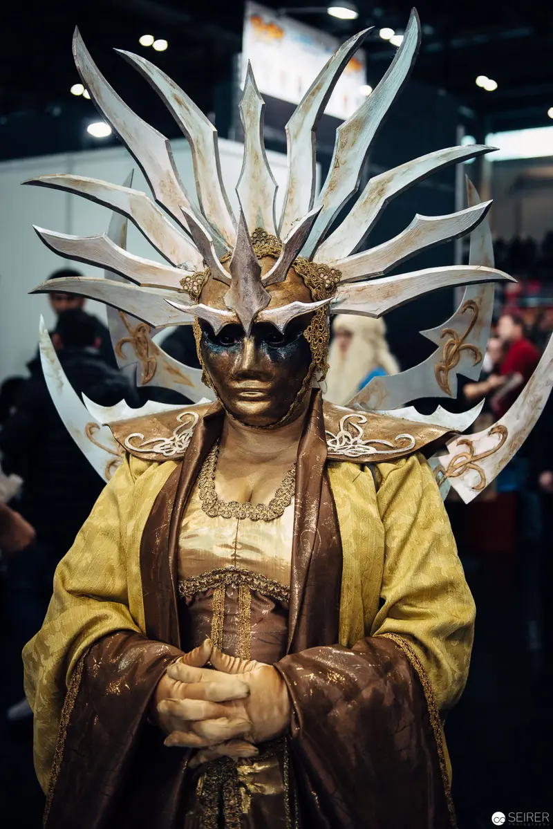 Elaborate Costumed Figure in Ornate Mask and Sculptural Headdress at Performance Event