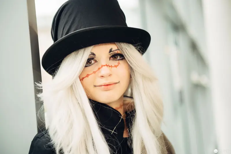 Blonde Figure in Black Hat with Expressive Theatrical Makeup