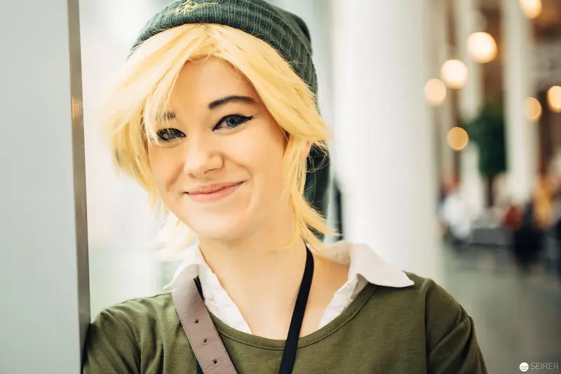 Young Woman in Green Beanie with Blonde Hair at Indoor Location