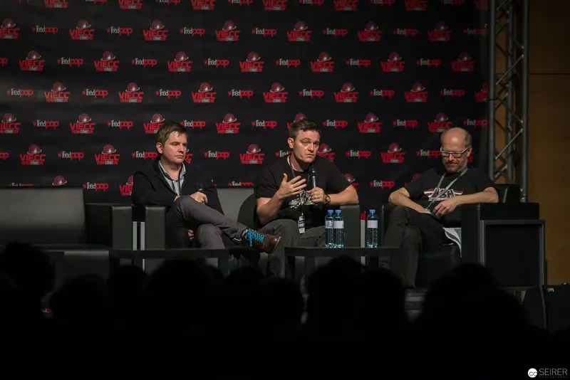 Panel Discussion at Fan Convention with Three Speakers on Stage