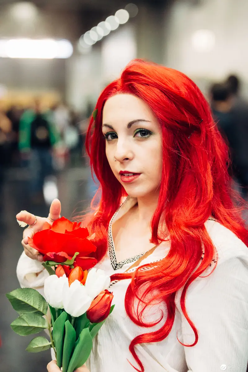 Vibrant Red-Haired Woman Holding Tulips in Indoor Environmental Setting