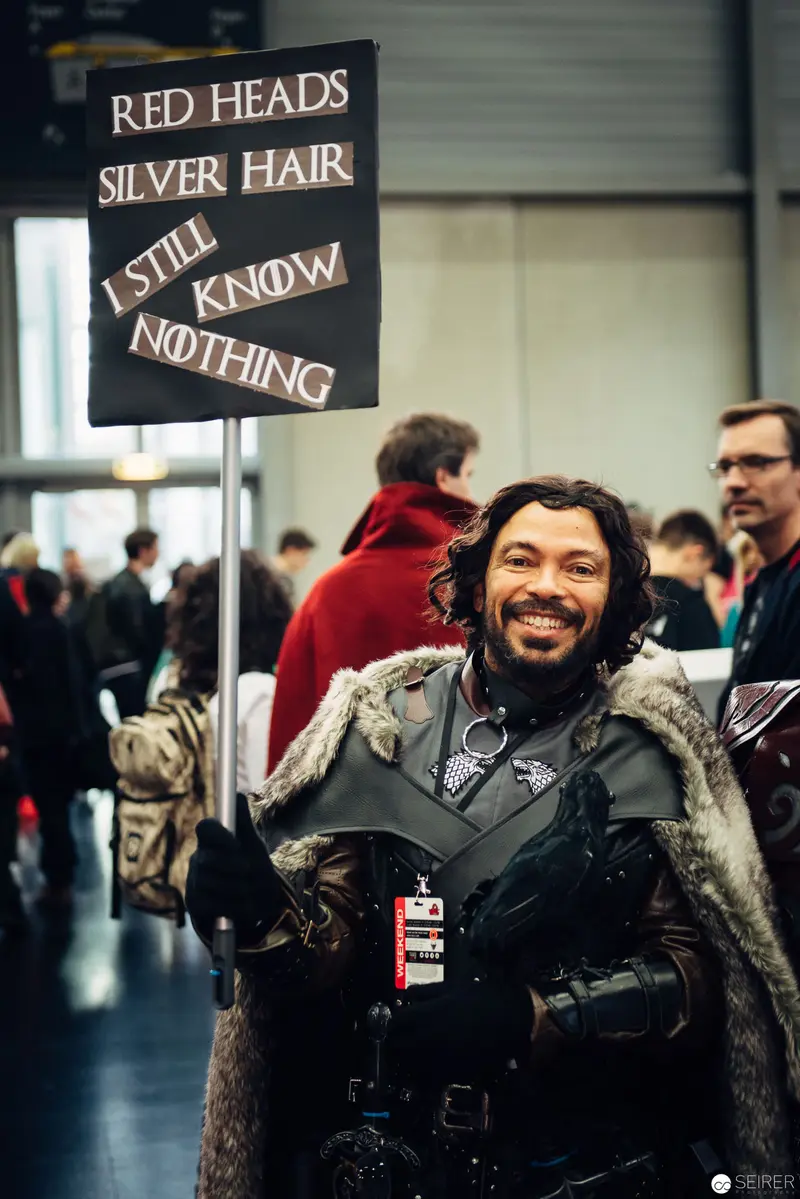 Costumed Convention Attendee Holds Humorous Game of Thrones Parody Sign