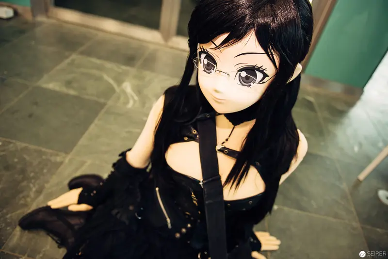 Anime-Style Doll in Black Avant-Garde Fashion Seated on Stone Floor