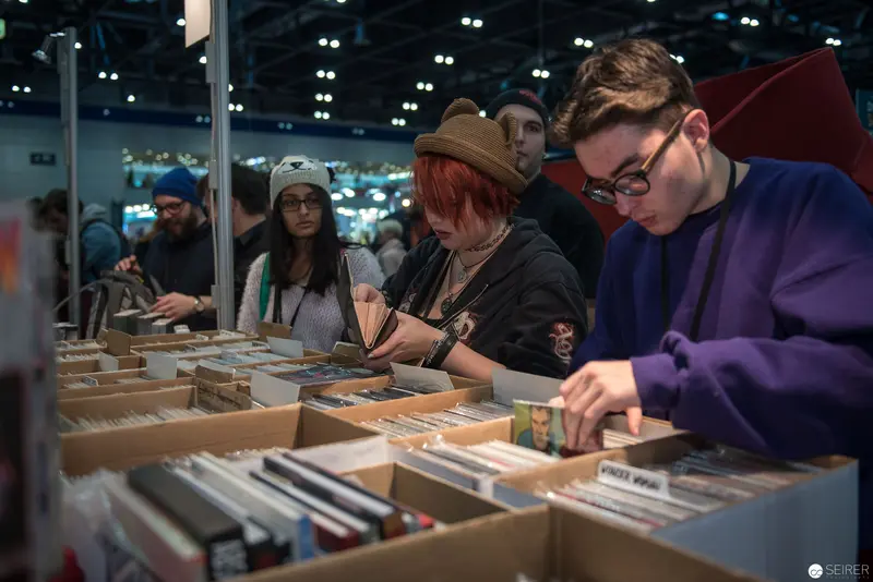 Young Bibliophiles Searching through Vintage Book Collection at Cultural Event