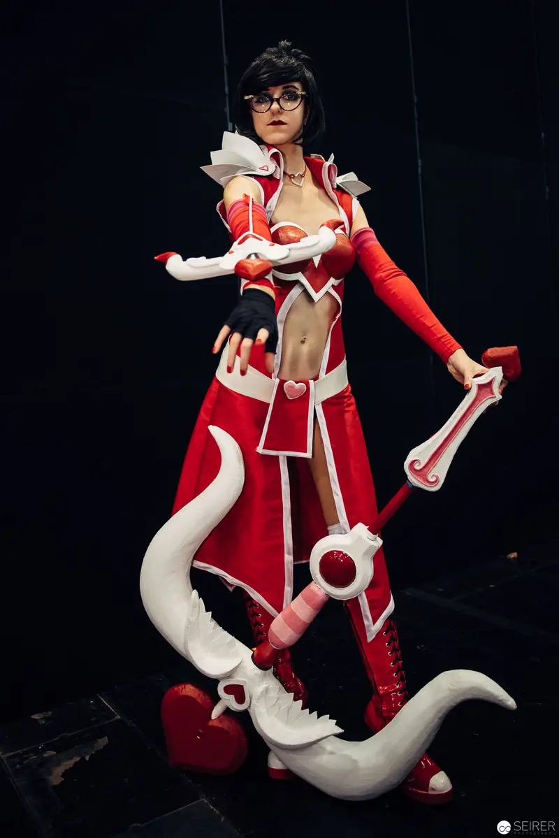 Cosplay Portraiture of Female Character in Red and White Costume with Stylized Weapon