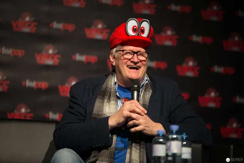 Gaming Icon in Red Cap Speaks at Media Event with Infectious Enthusiasm