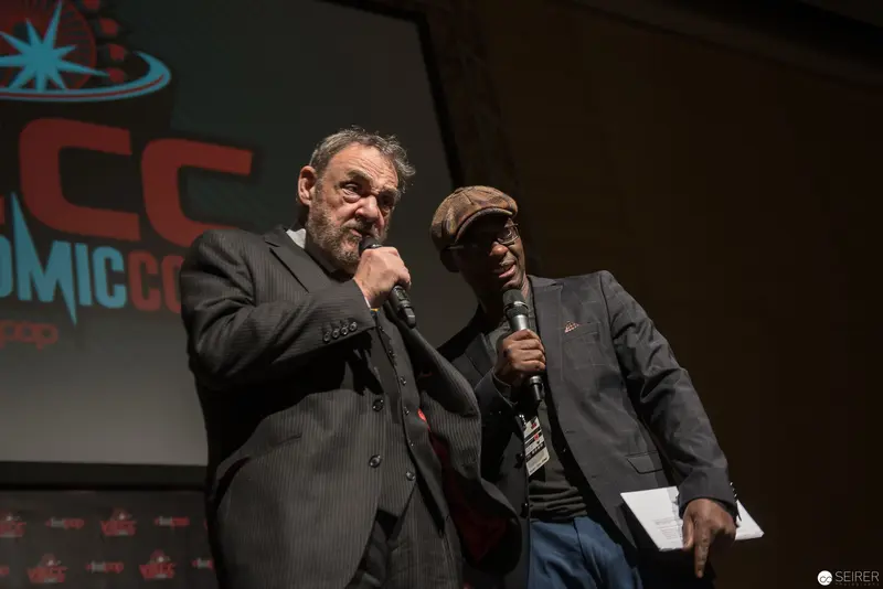 Comic Con Stage: Two Performers with Microphones in Dramatic Interaction
