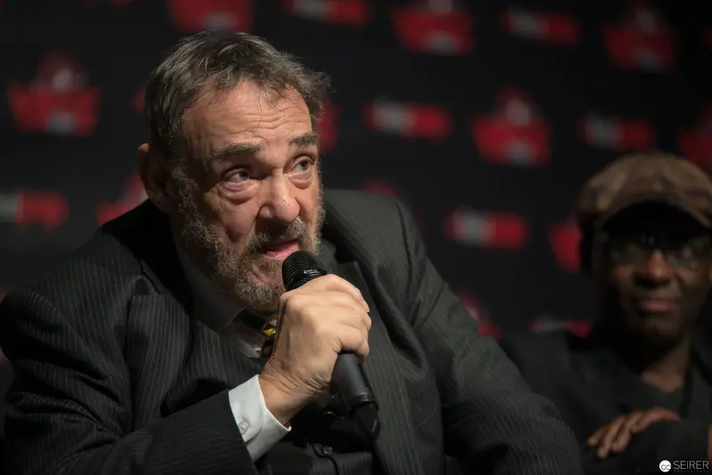 Intense Performer Gripping Microphone Against Branded Backdrop