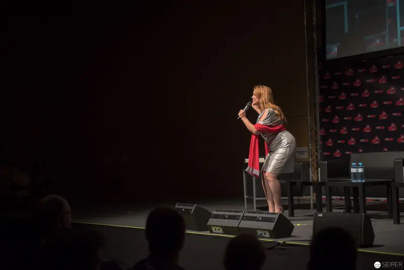 Solo Performance with Red Scarf on Dark Stage at Conference Event