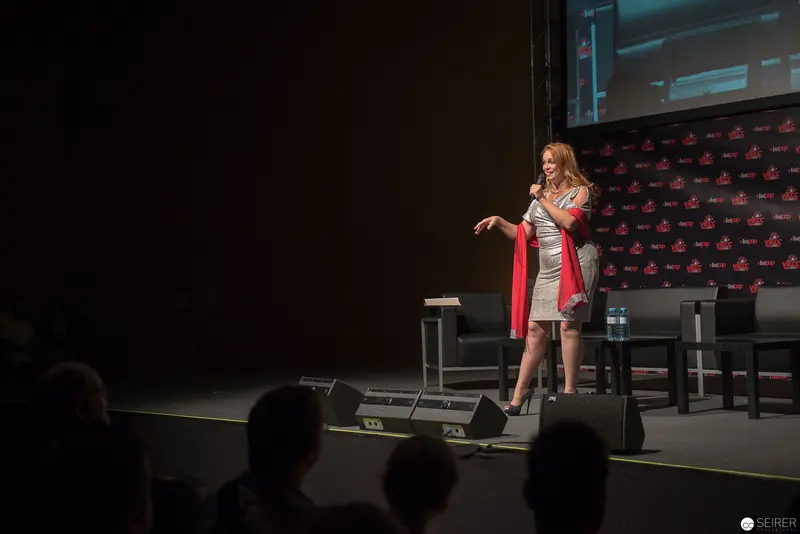 Speaker Presenting at Conference Stage with Red Accent Wrap