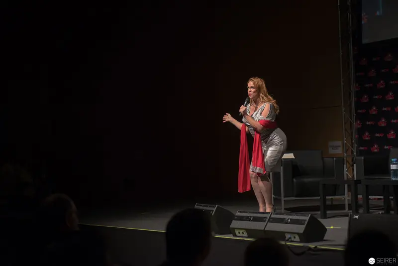 Solo Performance of Woman Speaker on Dark Stage with Red Accent