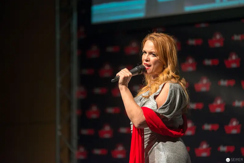 Performer on Stage with Microphone at Red-Branded Press Conference