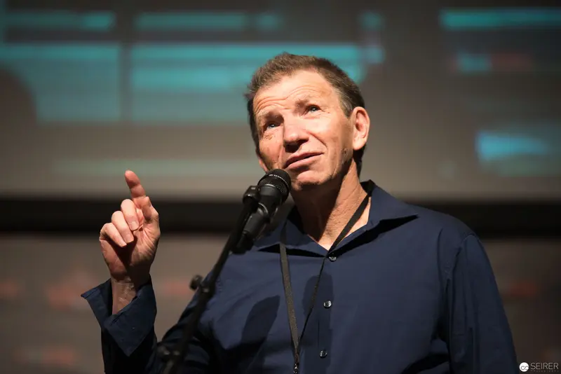 Middle-Aged Speaker Gesturing Emphatically During Presentation