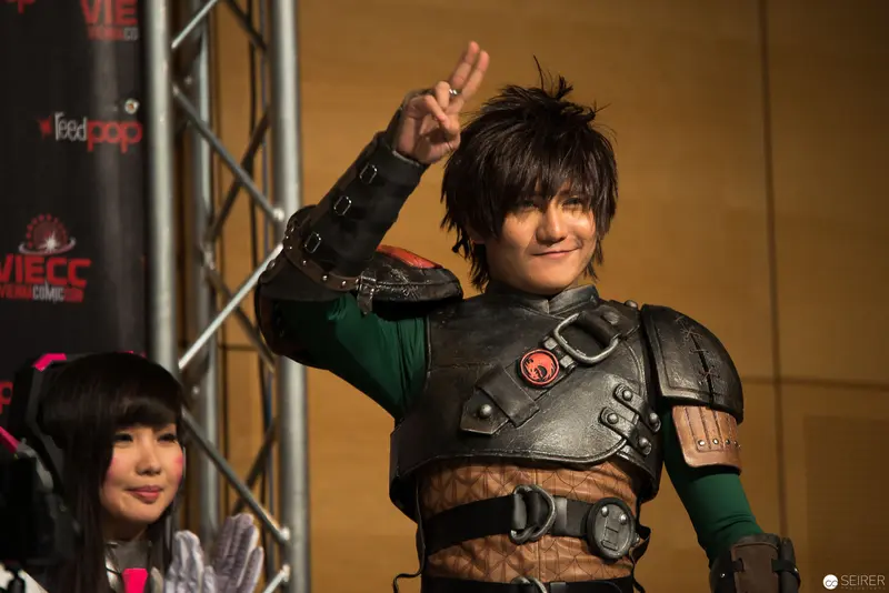 Costumed Performer in Armored Outfit Gestures at Convention Event