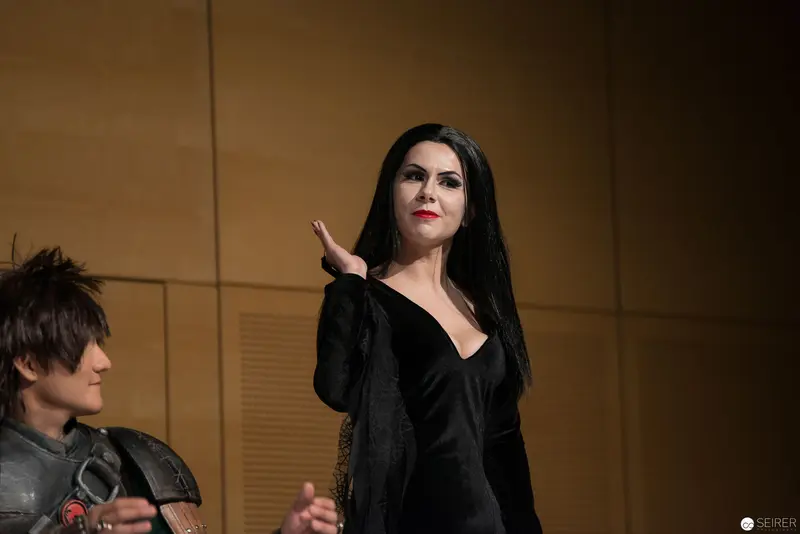 Gothic-Styled Woman in Black Gesturing Dramatically on Stage