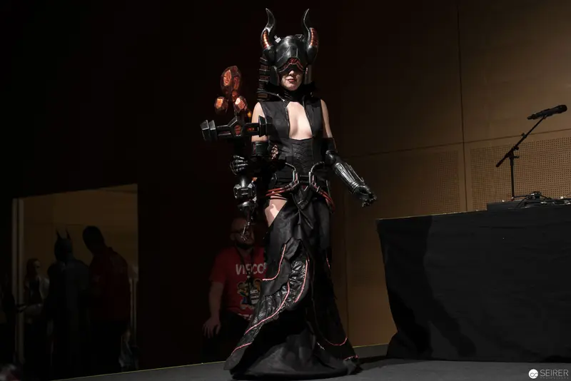 Costumed Performer in Horned Mask and Dark Armor on Stage