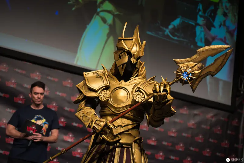 Golden Armored Cosplay Figure at Convention Presenting Elaborate Costume Design
