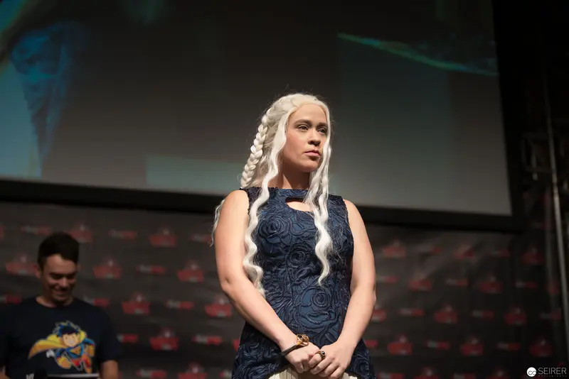 Costumed Performer with Braided White Hair at Fan Convention Podium